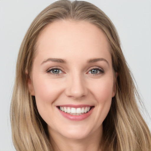 Joyful white young-adult female with long  brown hair and blue eyes