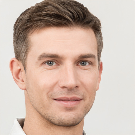 Joyful white young-adult male with short  brown hair and grey eyes