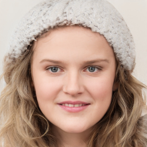 Joyful white young-adult female with long  brown hair and blue eyes