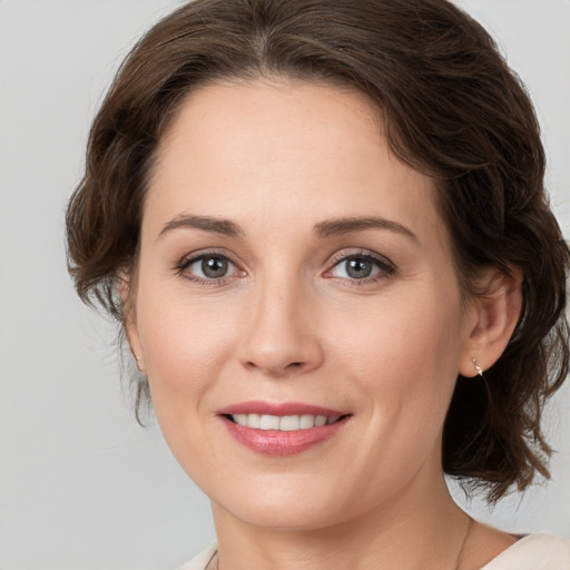 Joyful white young-adult female with medium  brown hair and grey eyes