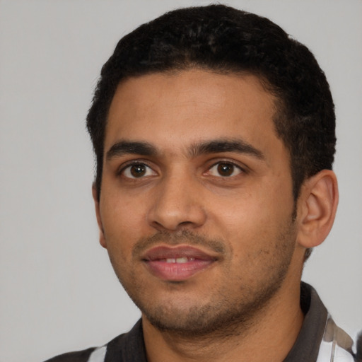 Joyful latino young-adult male with short  black hair and brown eyes