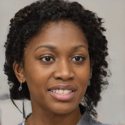 Joyful black young-adult female with long  brown hair and brown eyes