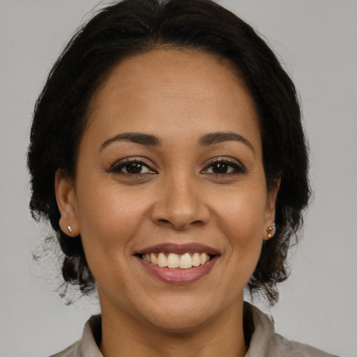 Joyful latino adult female with medium  brown hair and brown eyes