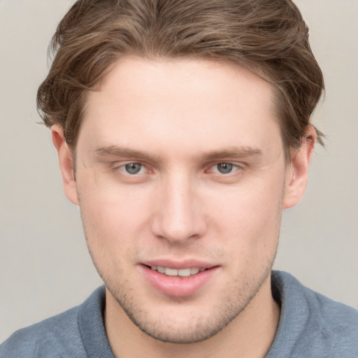 Joyful white young-adult male with short  brown hair and grey eyes