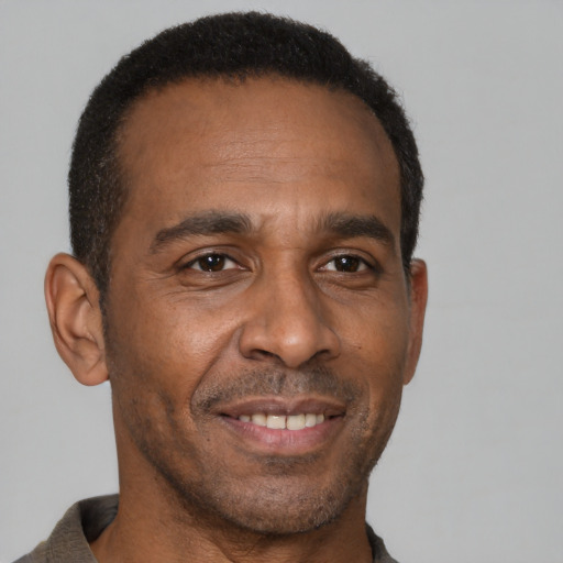 Joyful black adult male with short  brown hair and brown eyes