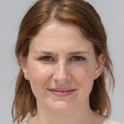 Joyful white adult female with medium  brown hair and blue eyes