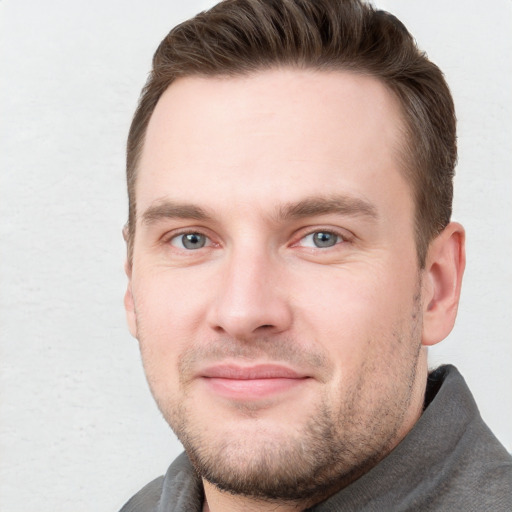 Joyful white young-adult male with short  brown hair and grey eyes