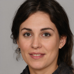 Joyful white adult female with medium  brown hair and brown eyes