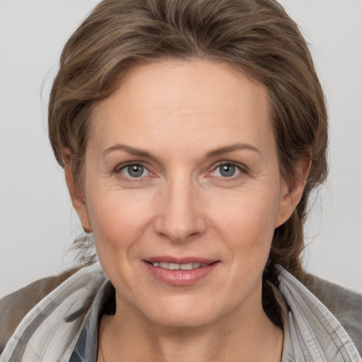 Joyful white adult female with medium  brown hair and grey eyes