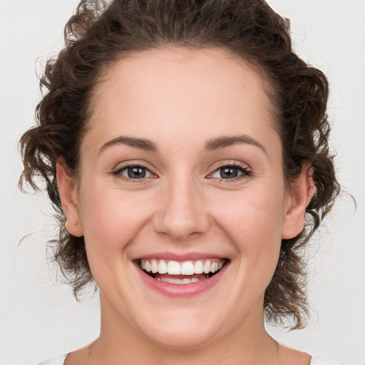 Joyful white young-adult female with medium  brown hair and green eyes