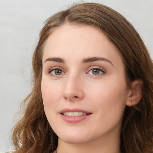 Joyful white young-adult female with long  brown hair and green eyes