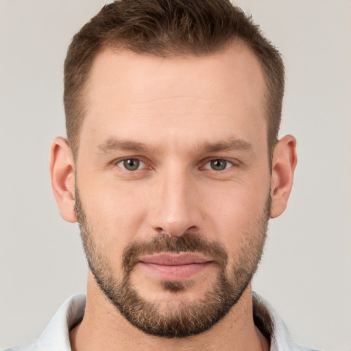 Joyful white young-adult male with short  brown hair and grey eyes