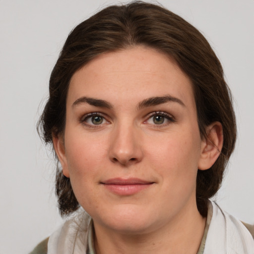 Joyful white young-adult female with medium  brown hair and green eyes