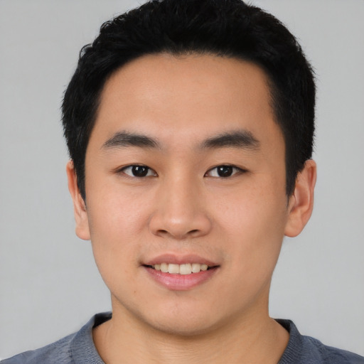 Joyful asian young-adult male with short  black hair and brown eyes
