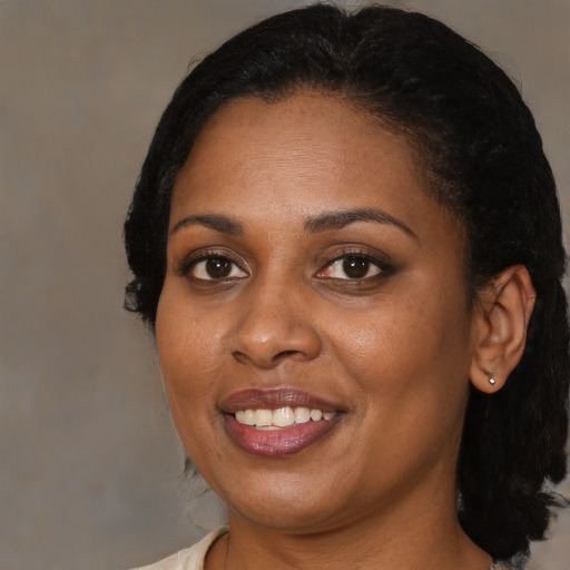 Joyful black adult female with medium  black hair and brown eyes