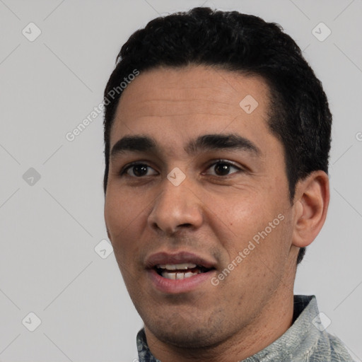 Joyful white young-adult male with short  black hair and brown eyes