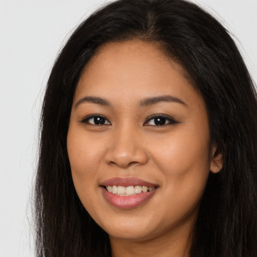 Joyful latino young-adult female with long  brown hair and brown eyes
