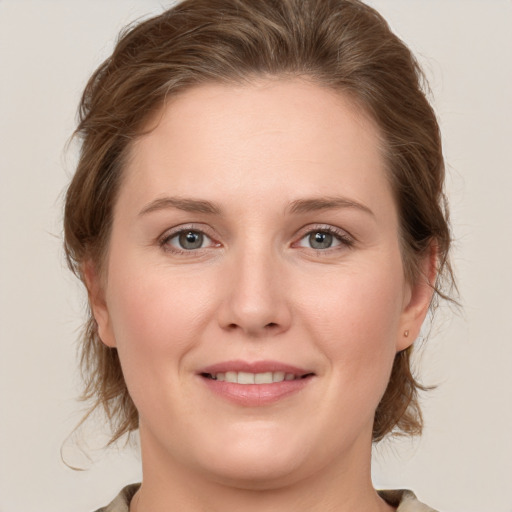 Joyful white young-adult female with medium  brown hair and grey eyes