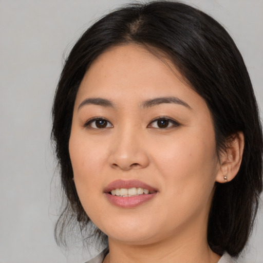 Joyful asian young-adult female with medium  black hair and brown eyes