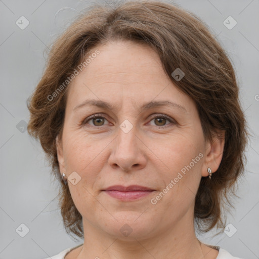 Joyful white adult female with medium  brown hair and green eyes