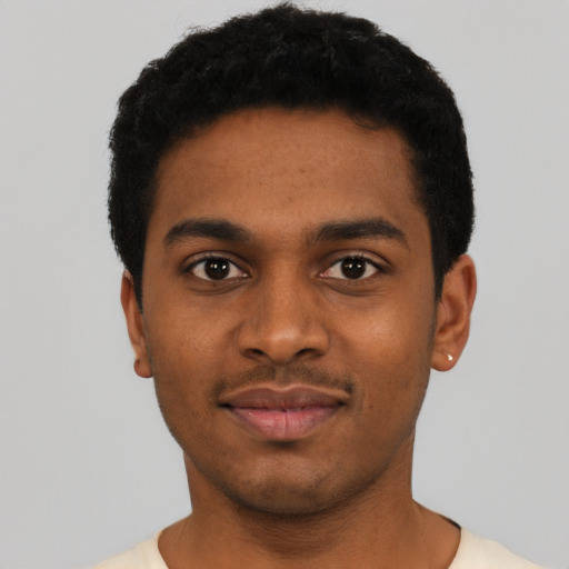 Joyful black young-adult male with short  black hair and brown eyes