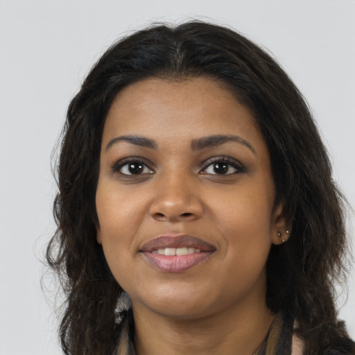 Joyful black young-adult female with long  brown hair and brown eyes