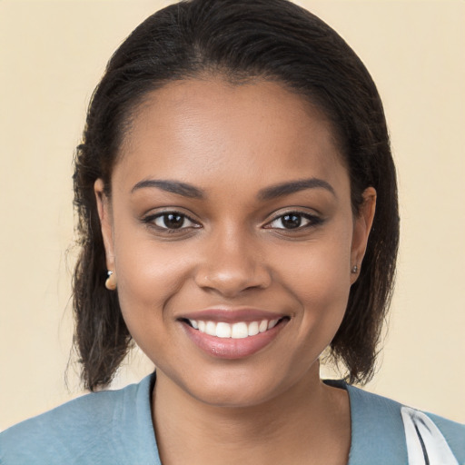 Joyful black young-adult female with medium  brown hair and brown eyes