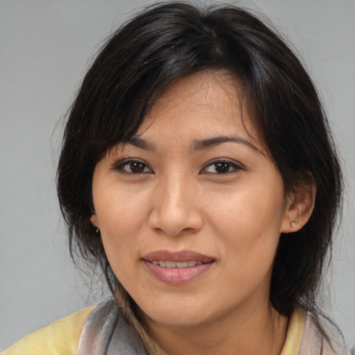 Joyful asian adult female with medium  brown hair and brown eyes