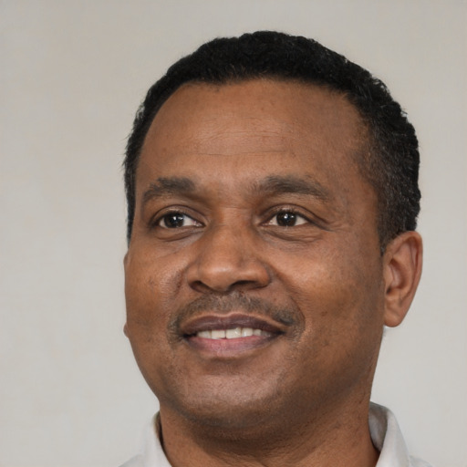 Joyful black adult male with short  black hair and brown eyes