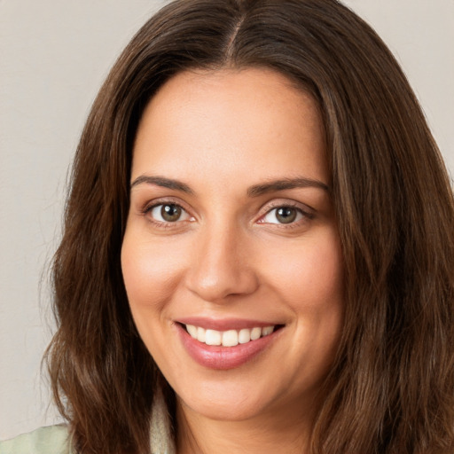 Joyful white young-adult female with long  brown hair and green eyes