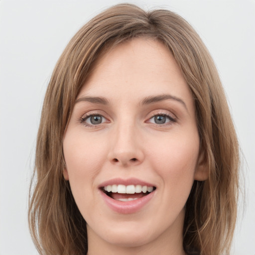 Joyful white young-adult female with long  brown hair and green eyes