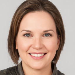 Joyful white young-adult female with medium  brown hair and grey eyes