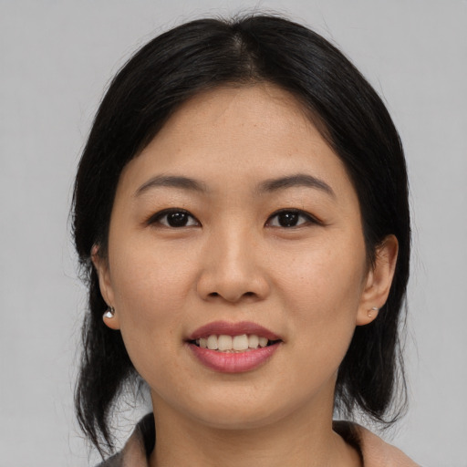 Joyful asian young-adult female with medium  black hair and brown eyes