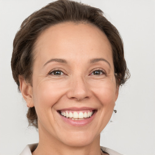 Joyful white adult female with medium  brown hair and grey eyes