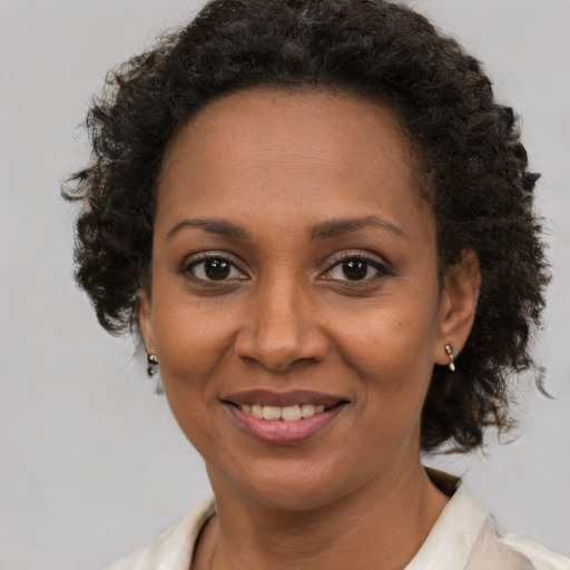 Joyful black adult female with medium  brown hair and brown eyes