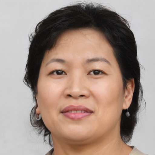 Joyful asian adult female with medium  brown hair and brown eyes