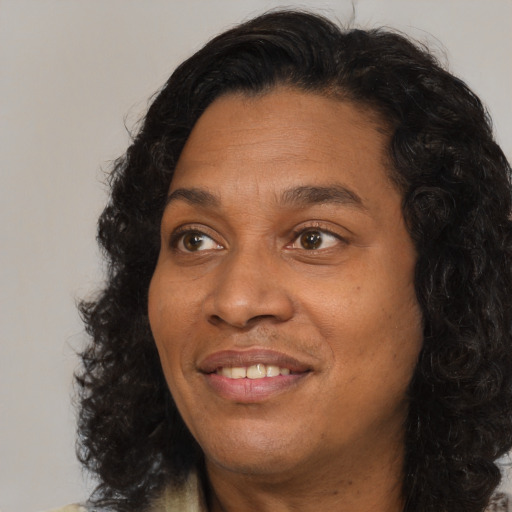 Joyful black adult female with long  brown hair and brown eyes