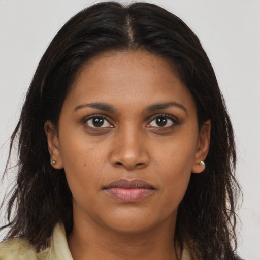 Joyful black young-adult female with long  brown hair and brown eyes