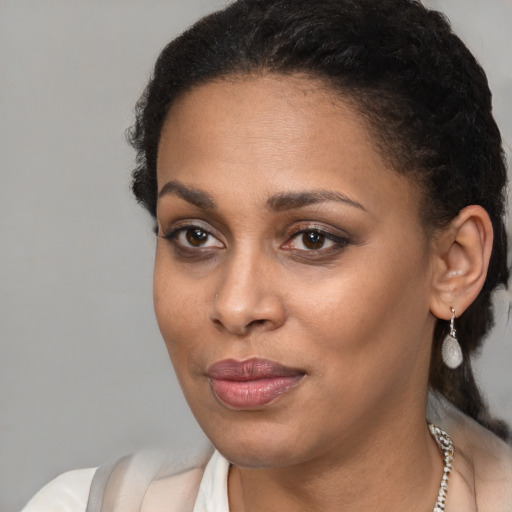 Joyful black young-adult female with short  brown hair and brown eyes