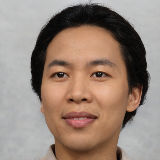 Joyful asian young-adult male with medium  black hair and brown eyes