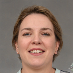 Joyful white adult female with medium  brown hair and grey eyes