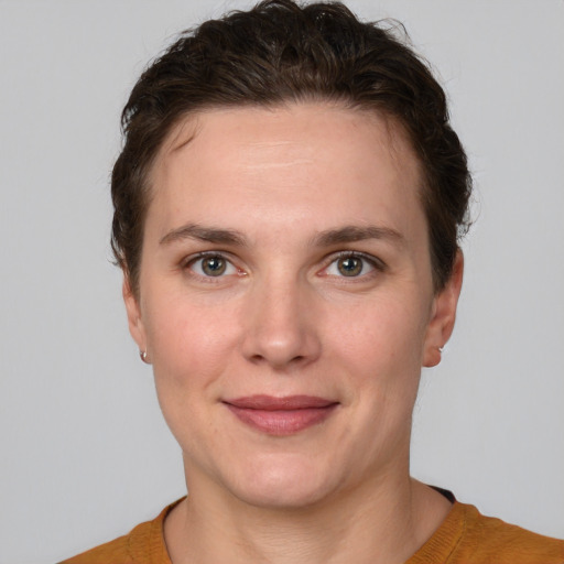 Joyful white young-adult female with short  brown hair and grey eyes