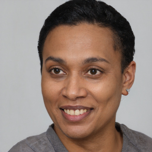 Joyful latino young-adult female with short  black hair and brown eyes
