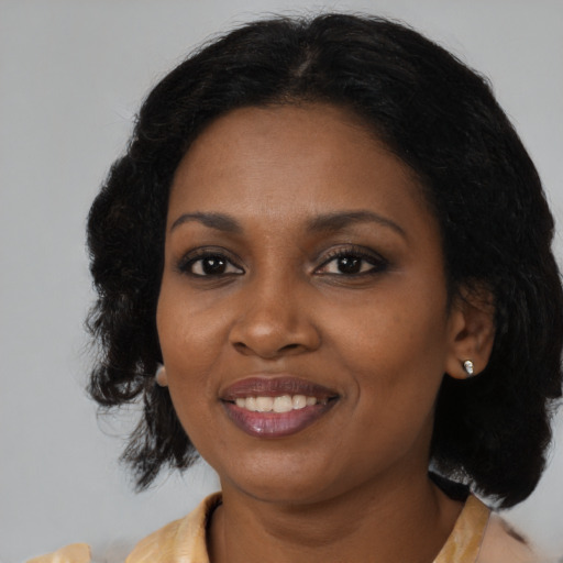 Joyful black young-adult female with medium  black hair and brown eyes