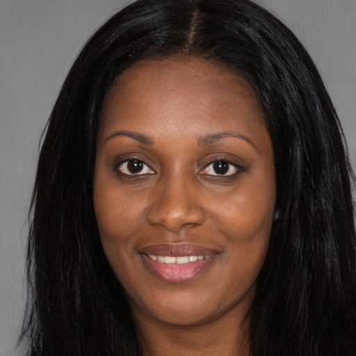 Joyful black young-adult female with long  black hair and brown eyes