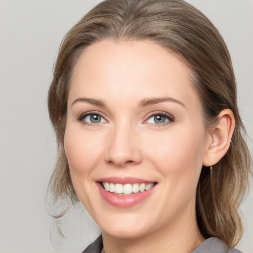 Joyful white young-adult female with medium  brown hair and grey eyes