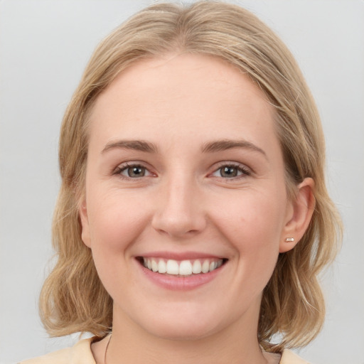 Joyful white young-adult female with medium  brown hair and blue eyes