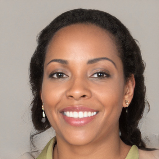 Joyful black young-adult female with long  brown hair and brown eyes