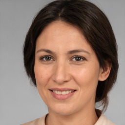 Joyful white adult female with medium  brown hair and brown eyes