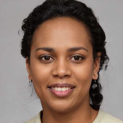 Joyful black young-adult female with short  black hair and brown eyes